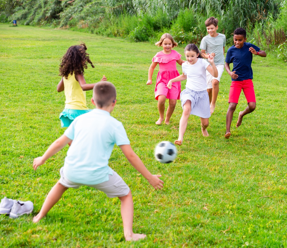 Children playing soccer together outdoors